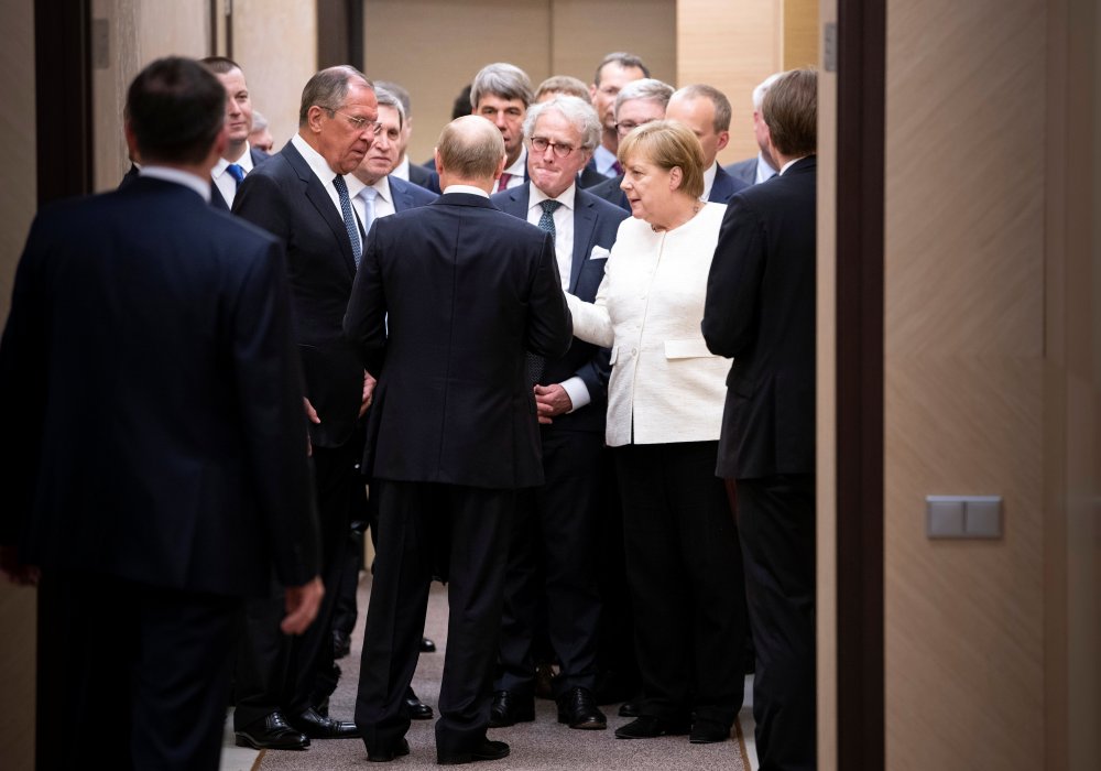Владимир Путин и Сергей Лавров беседуют с канцлером Германии Ангелой Меркель на встрече в Сочи. © Reuters