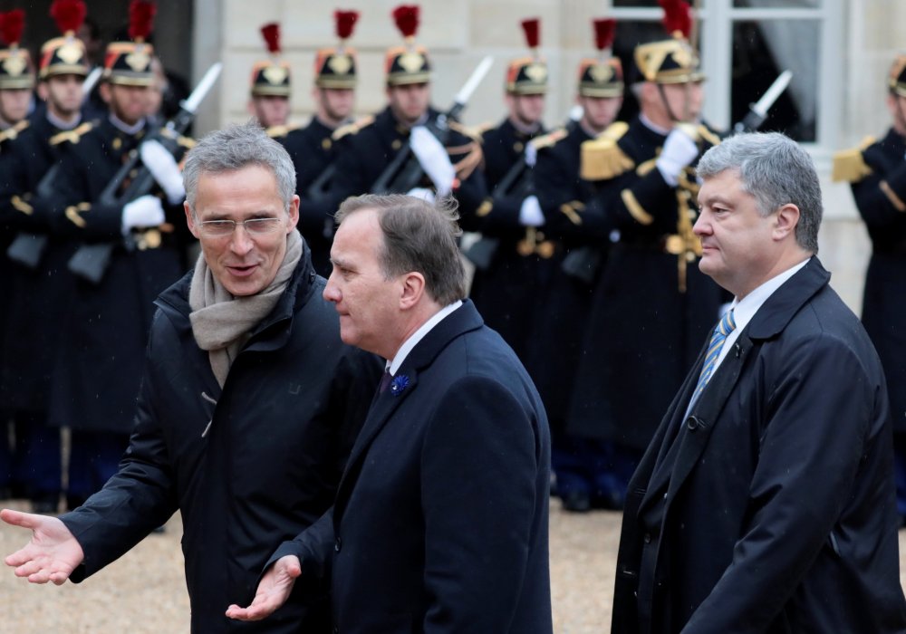 Президент Украины Петр Порошенко, премьер-министр Швеции Стефан Левен и генсек НАТО Йенс Столтенберг у входа в Елисейский дворец в Париже. © Reuters