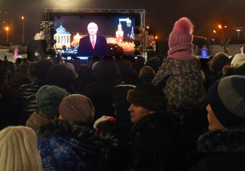 Россияне слушают новогоднее обращение Владимира Путина. © РИА Новости/Максим Богодвид