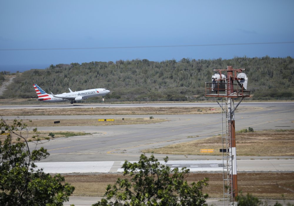Самолет взлетает со взлетно-посадочной полосы в аэропорту Каракаса. © Reuters
