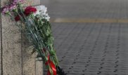 Люди несут цветы к зданию аэропорта Алматы