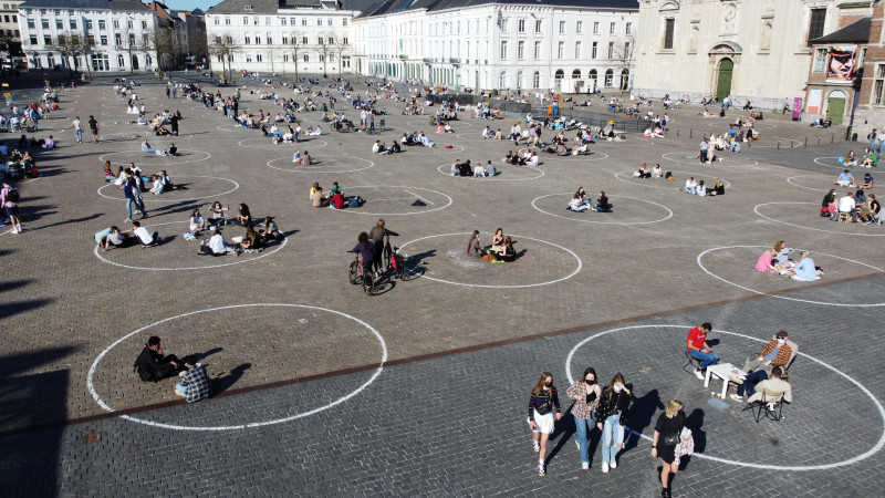 Люди отдыхают в кругах, нарисованных местными властями на площади Святого Петра в Генте, Бельгия. Фото ©REUTERS
