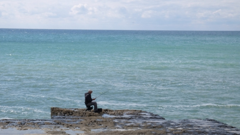 Мужчина рыбачит на берегу Каспийского моря в Актау. © РИА Новости