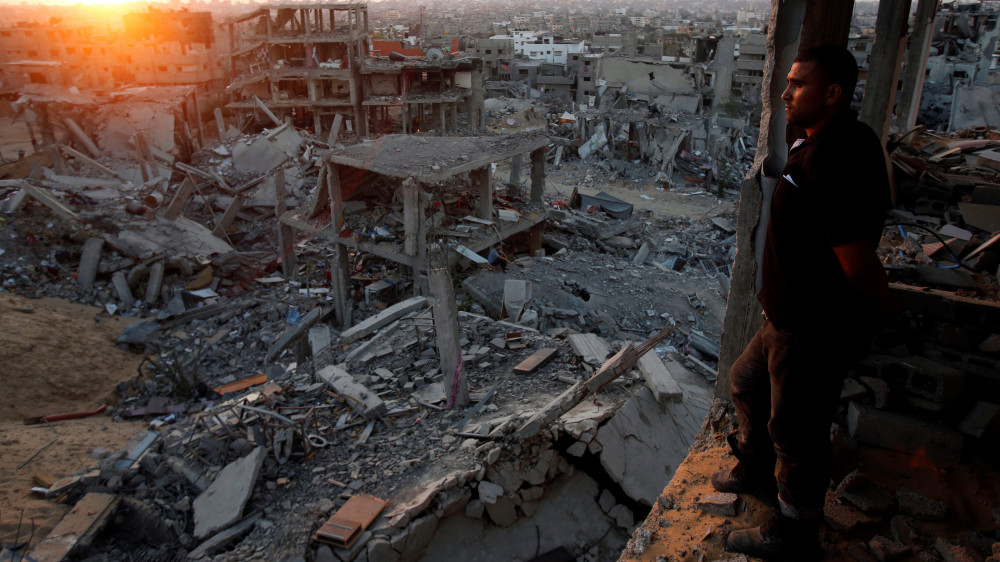 Палестинец смотрит на разрушеные от авиаударов строения в секторе Газа. © Reuters
