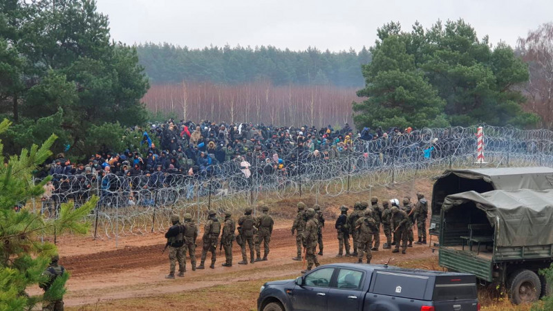 Польские солдаты и сотни мигрантов по разные стороны колючей проволоки на границе с Беларусью. ©REUTERS