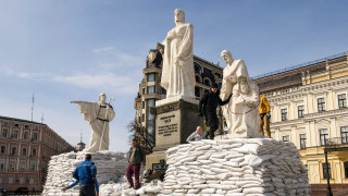 Волонтеры для защиты закрывают памятник мешками с песком. Фото ©REUTERS