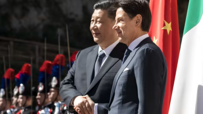 Си Цзиньпин и Джузеппе Конте обменялись рукопожатием перед подписанием меморандума по проекту "Один пояс, один путь". © Bloomberg