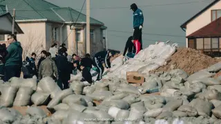 Активисты партии Amanat возводят противопаводковую дамбу в Атырау