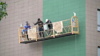 В Костанае бастующим на высоте строителям подняли пакет с деньгами на веревке